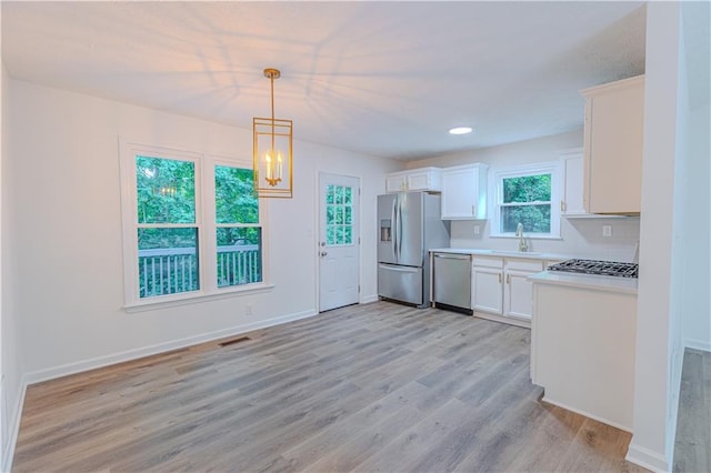 159 Aztec Way SE, Acworth, GA 30102 - kitchen featuring stainless steel appliances, light countertops, white cabinetry, a sink, and light wood-type flooring