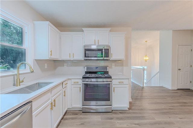 159 Aztec Way SE, Acworth, GA 30102 - kitchen with stainless steel appliances, a sink, white cabinets, light countertops, and backsplash