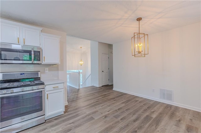 159 Aztec Way SE, Acworth, GA 30102 - kitchen with appliances with stainless steel finishes, light wood-style flooring, white cabinetry, light countertops, and a chandelier