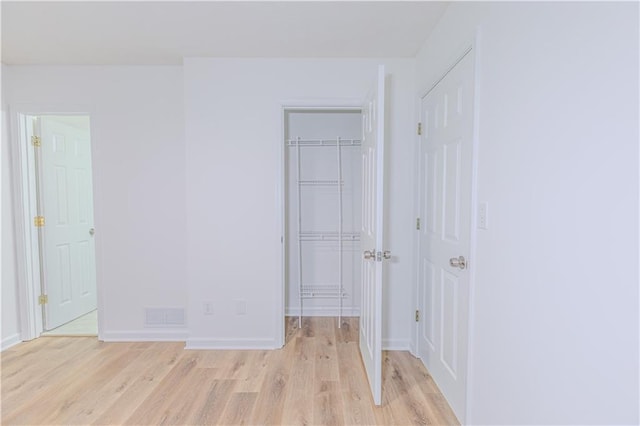 159 Aztec Way SE, Acworth, GA 30102 - unfurnished bedroom featuring light wood-style floors, a walk in closet, a closet, and baseboards
