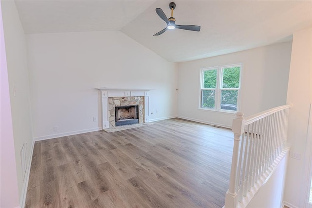 159 Aztec Way SE, Acworth, GA 30102 - unfurnished living room with wood finished floors, ceiling fan, a fireplace, lofted ceiling, and baseboards