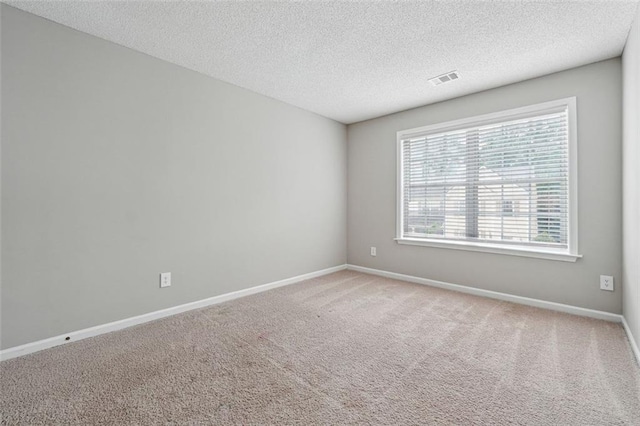 carpeted empty room featuring baseboards and a textured ceiling