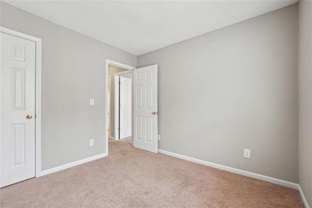unfurnished bedroom with carpet floors and baseboards
