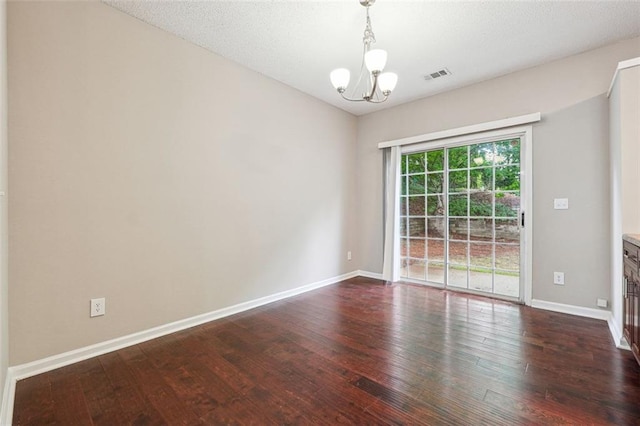 unfurnished room with a chandelier, dark wood-style flooring, and baseboards