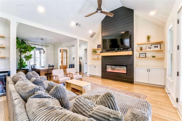 living room featuring a fireplace, light hardwood / wood-style floors, ceiling fan, and lofted ceiling