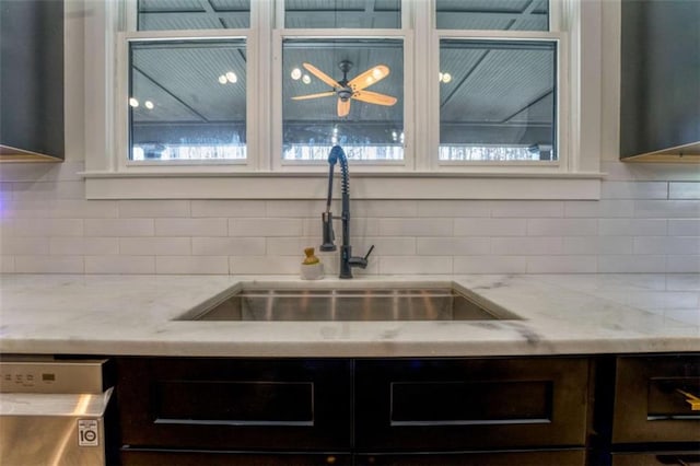 kitchen with dishwasher, sink, light stone countertops, and backsplash