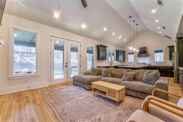 living room with sink, french doors, plenty of natural light, and light wood-type flooring