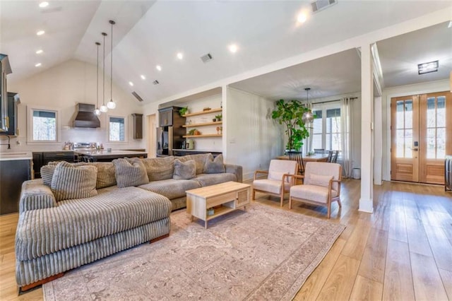 living room featuring light wood-type flooring, sink, high vaulted ceiling, and french doors