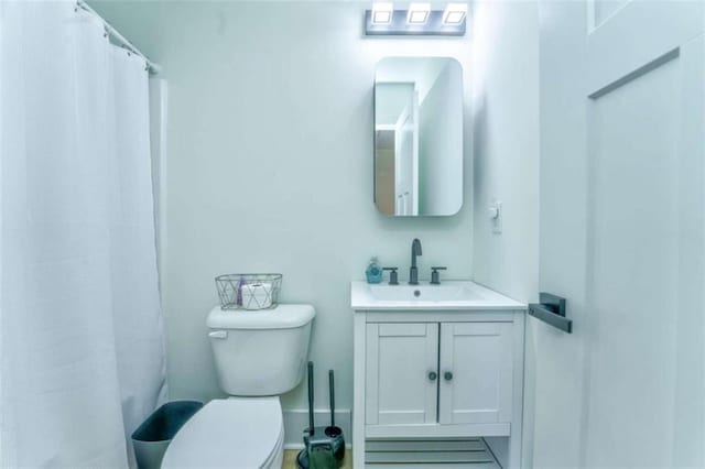 bathroom featuring a shower with curtain, vanity, and toilet