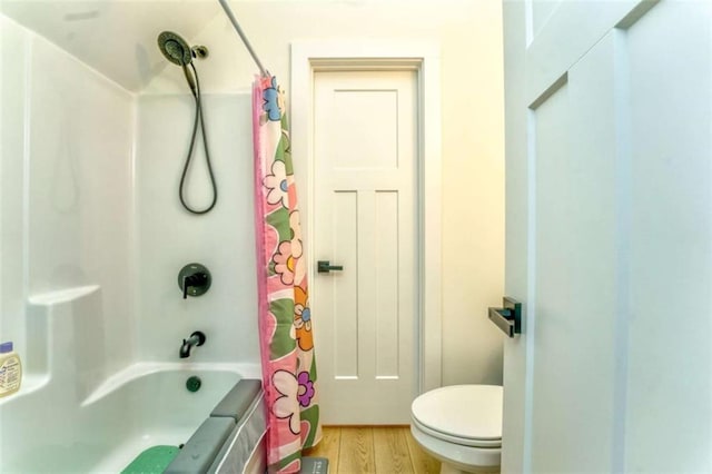 bathroom featuring shower / tub combo, hardwood / wood-style flooring, and toilet