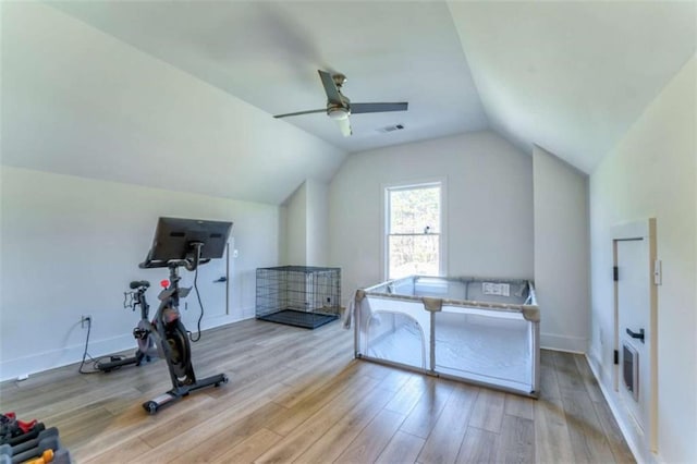 exercise room with ceiling fan, lofted ceiling, and light wood-type flooring