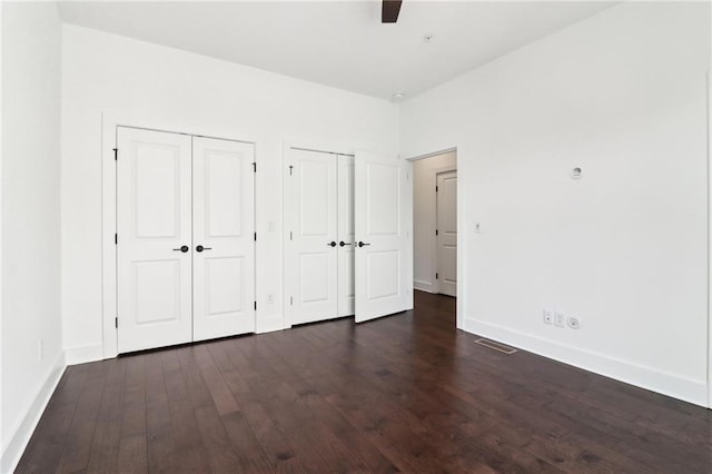 443 Plateau Pl NW, Atlanta, GA 30309 - unfurnished bedroom with baseboards, multiple closets, dark wood-style floors, and visible vents