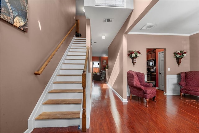 stairway featuring hardwood / wood-style flooring and crown molding