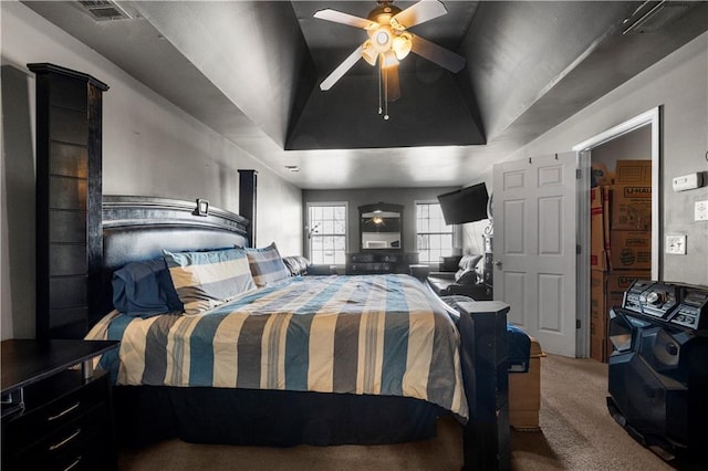 carpeted bedroom featuring a raised ceiling and ceiling fan