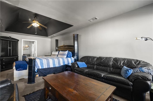 carpeted bedroom with a raised ceiling and ceiling fan