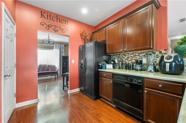 kitchen featuring tasteful backsplash, black appliances, and hardwood / wood-style flooring