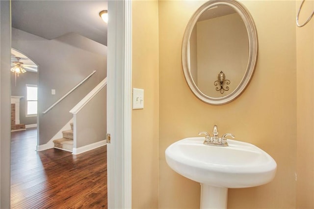 bathroom with hardwood / wood-style floors, a fireplace, sink, and ceiling fan