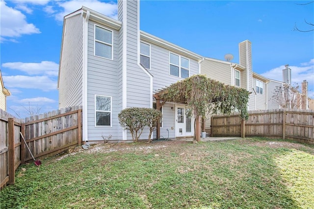 back of property with a pergola and a lawn