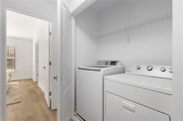 washroom with washer and dryer and light wood-type flooring