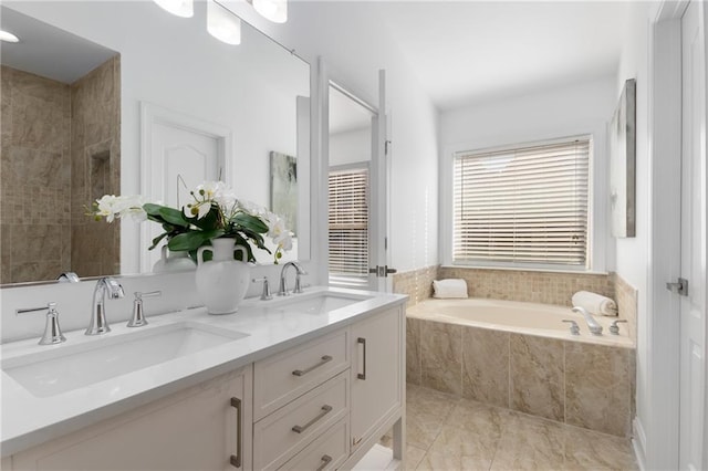 bathroom with tiled bath and vanity