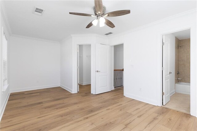 unfurnished bedroom featuring ceiling fan, light wood-type flooring, ornamental molding, and ensuite bath