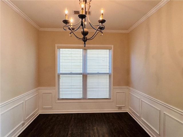 spare room with ornamental molding, an inviting chandelier, and dark wood-type flooring