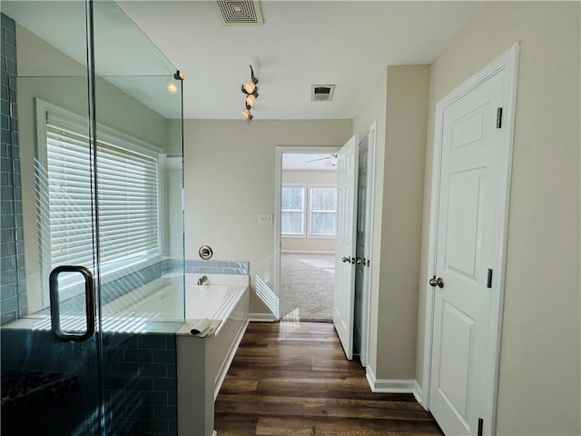 bathroom with separate shower and tub, ceiling fan, and wood-type flooring