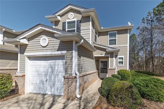 view of front of property featuring driveway, brick siding, and an attached garage