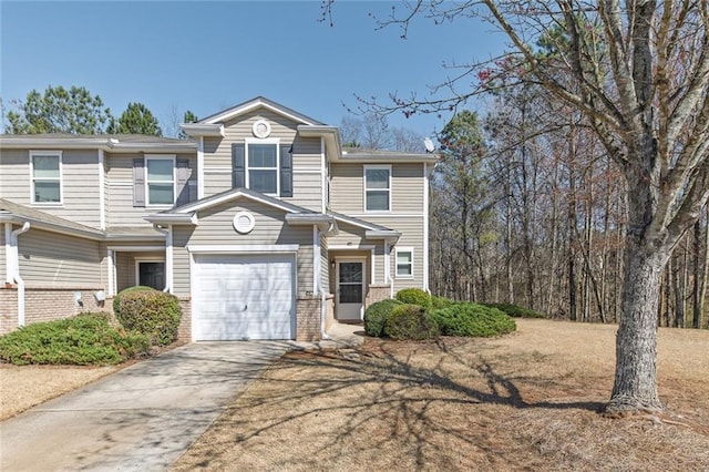 multi unit property featuring a garage, brick siding, and driveway