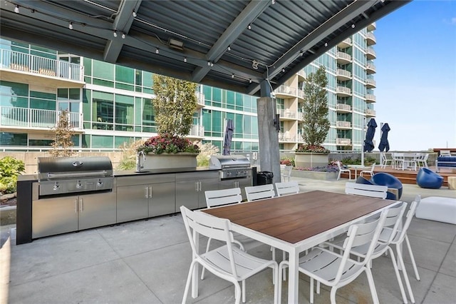 view of patio with an outdoor kitchen, area for grilling, and sink