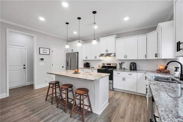 kitchen featuring a kitchen island, appliances with stainless steel finishes, sink, and white cabinets