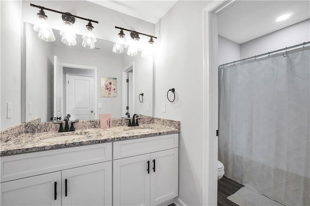 bathroom featuring vanity, hardwood / wood-style floors, curtained shower, and toilet