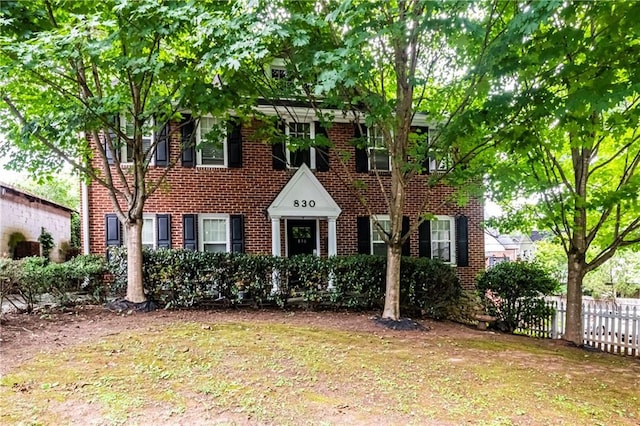 colonial-style house featuring a front yard