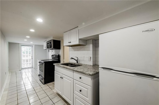 kitchen featuring sink, tasteful backsplash, light tile patterned floors, appliances with stainless steel finishes, and white cabinets