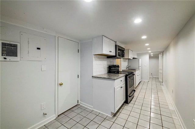 kitchen featuring light tile patterned floors, appliances with stainless steel finishes, white cabinetry, backsplash, and electric panel