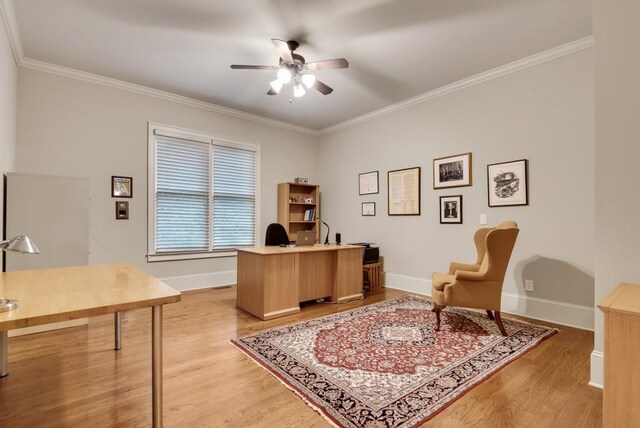office area featuring a ceiling fan, light wood-style flooring, crown molding, and baseboards