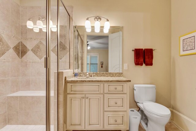 full bathroom with a shower stall, toilet, vanity, a ceiling fan, and baseboards