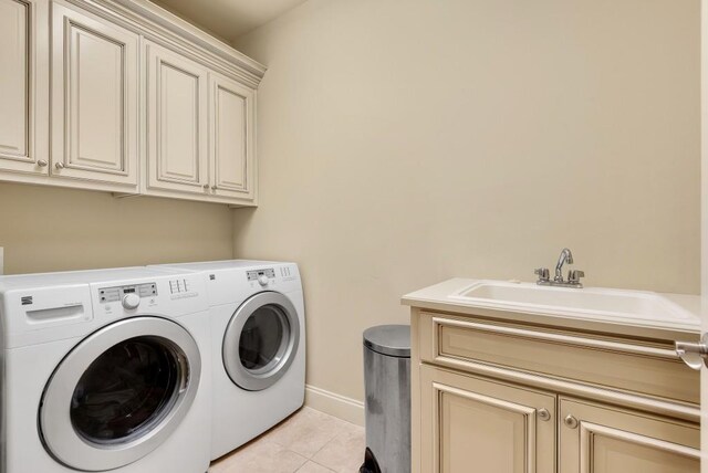 clothes washing area featuring cabinet space, washer and clothes dryer, light tile patterned floors, and baseboards