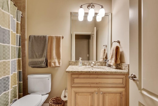 full bathroom with toilet, vanity, and curtained shower