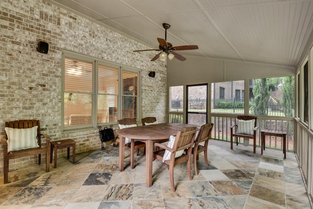 sunroom featuring a ceiling fan, healthy amount of natural light, lofted ceiling, and outdoor dining space