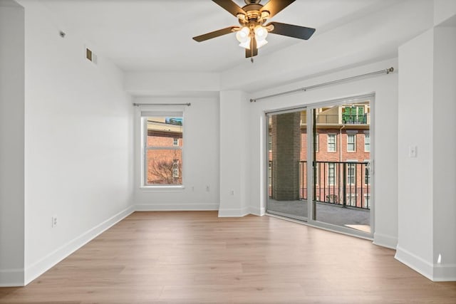 empty room featuring baseboards, visible vents, ceiling fan, and light wood finished floors