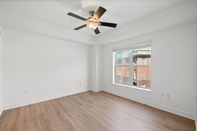 spare room featuring ceiling fan, baseboards, and wood finished floors