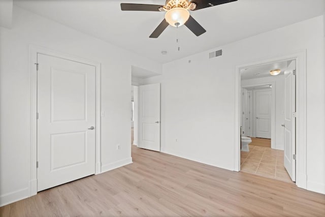 unfurnished bedroom featuring baseboards, a ceiling fan, visible vents, and light wood-style floors