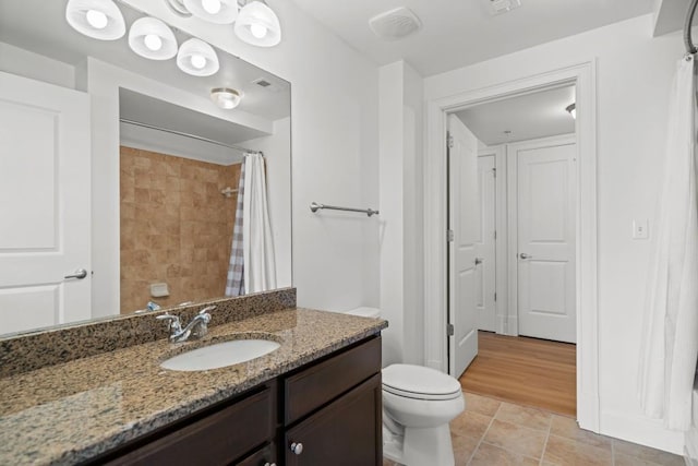 bathroom with tile patterned flooring, a shower with curtain, vanity, and toilet