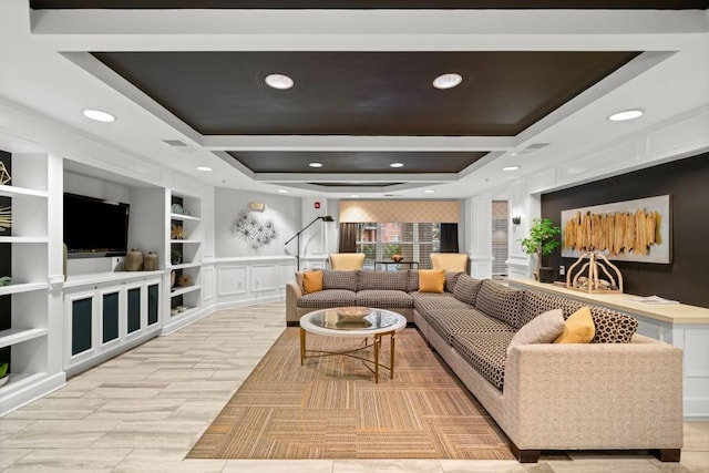 living room with built in shelves, recessed lighting, a decorative wall, visible vents, and a raised ceiling