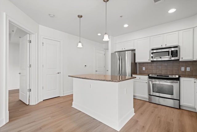 kitchen with stainless steel appliances, light wood-type flooring, and white cabinetry