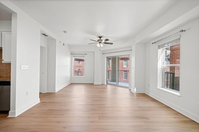 empty room featuring light wood-style floors, ceiling fan, and baseboards