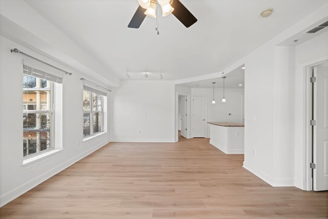 unfurnished living room featuring a ceiling fan, visible vents, light wood-style flooring, and baseboards