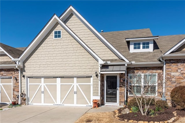 view of front of house with stone siding, driveway, and an attached garage