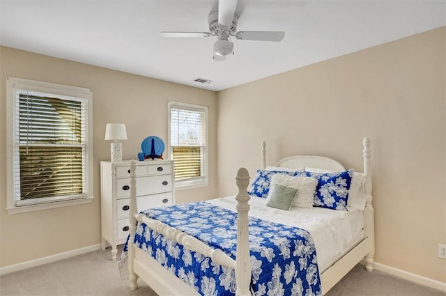 carpeted bedroom with visible vents, a ceiling fan, and baseboards